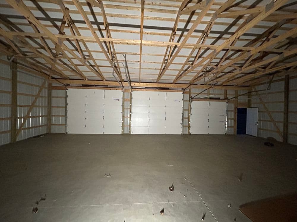 Spacious indoor garage with high ceilings and multiple garage doors. Ideal for storage or vehicles.